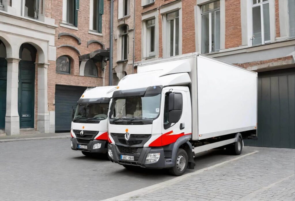 Location de camion avec chauffeur à Bruxelles : camions de déménagement garés dans une rue pavée